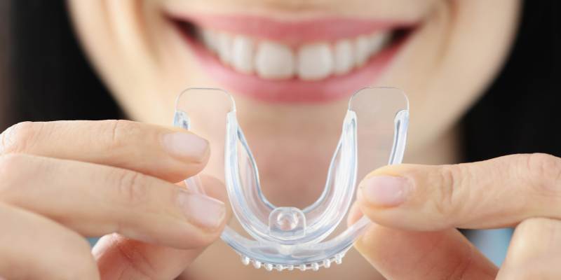 woman holding a dental bite guard to protect her teeth